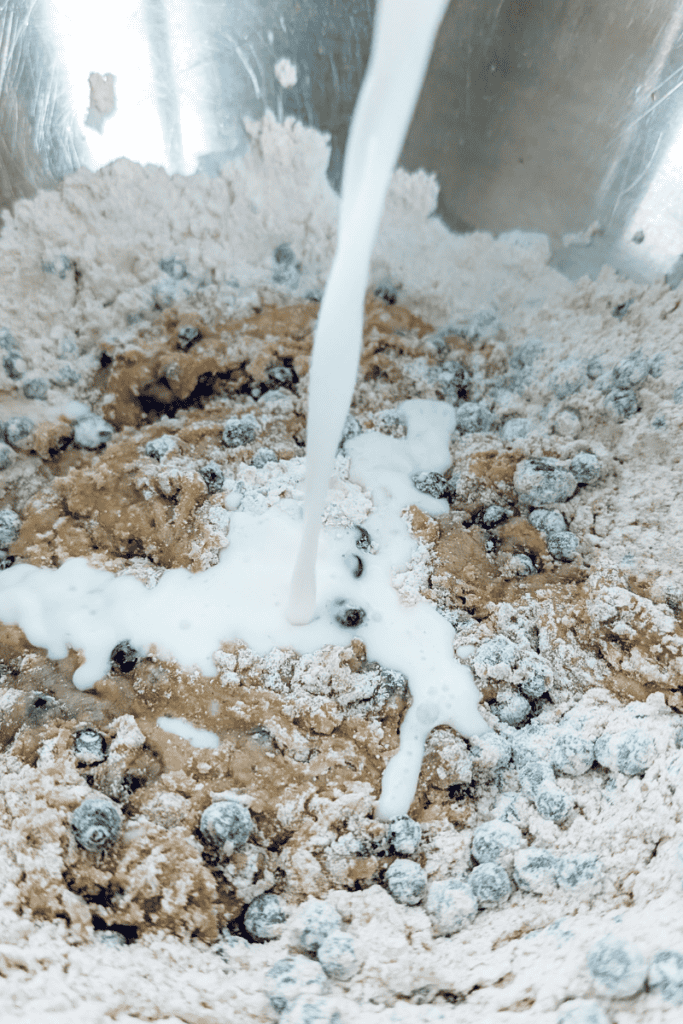 Blueberry muffin batter with frozen Canadian wild blueberries being mixed.