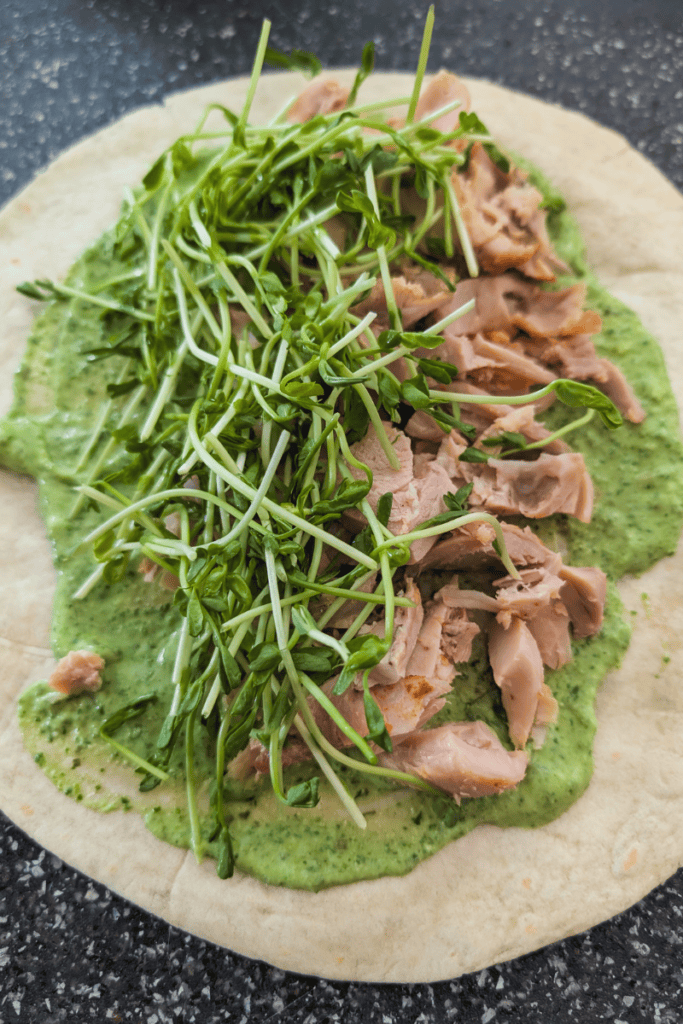 Healthy chicken wrap with fresh greens and creamy sauce.