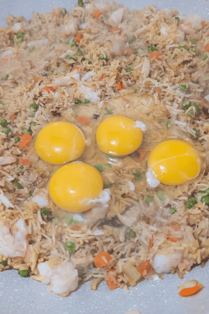 Delicious shrimp fried rice topped with four raw eggs, perfect for a quick weeknight dinner. Easy re.