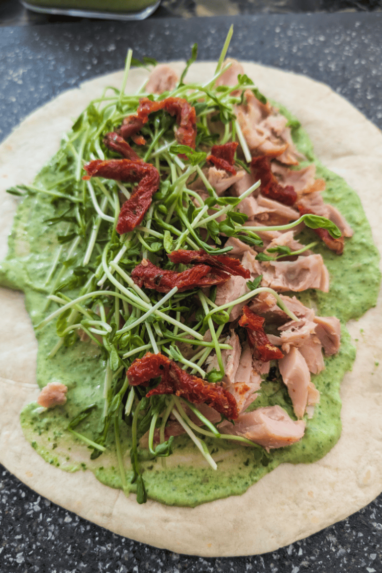 Healthy chicken wrap with greens and sun-dried tomatoes.