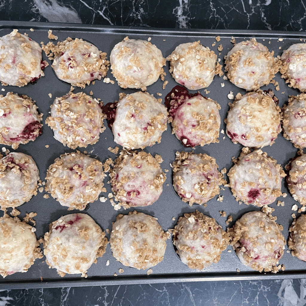 Delicious cherry berry cookie bites with crunchy topping on a baking tray.