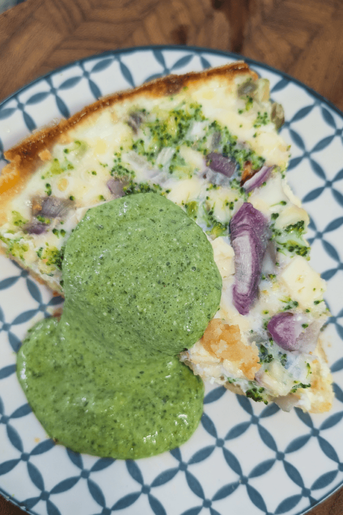 Delicious spinach and cottage cheese dip with herbs served on a patterned plate.