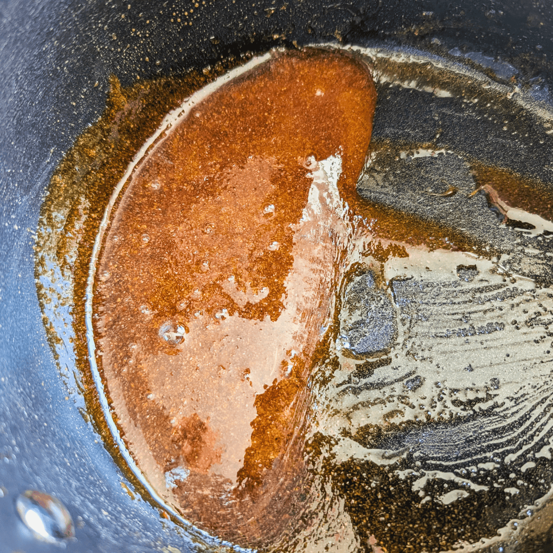 Maple glaze in a pan for oven-cooked ribs, sticky and flavorful.
