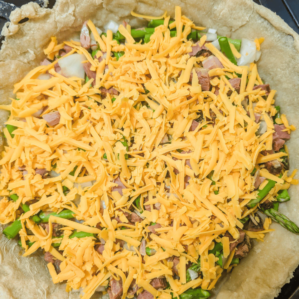 Ham and asparagus quiche with cheese and fresh vegetables for a hearty family meal. Perfect for brun.