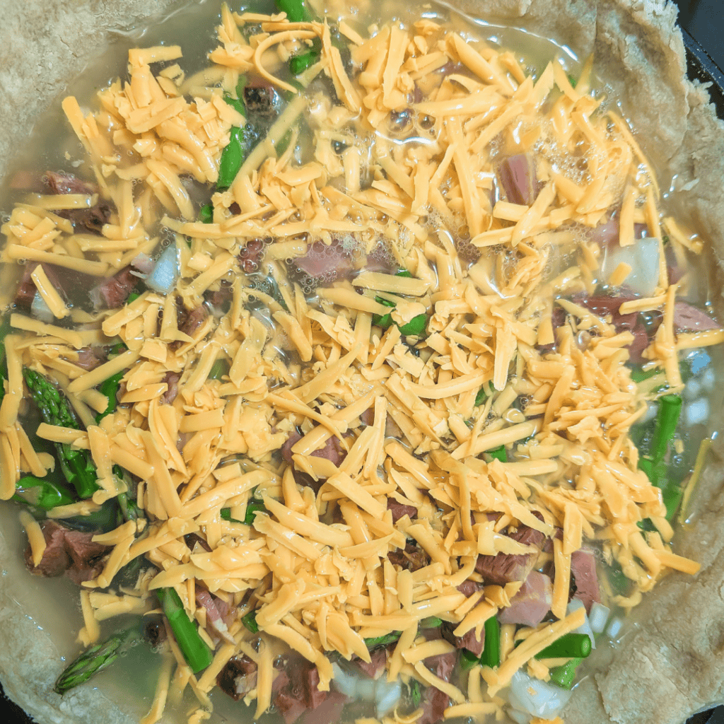 Ham and asparagus filling for a family-sized quiche, ready to bake.
