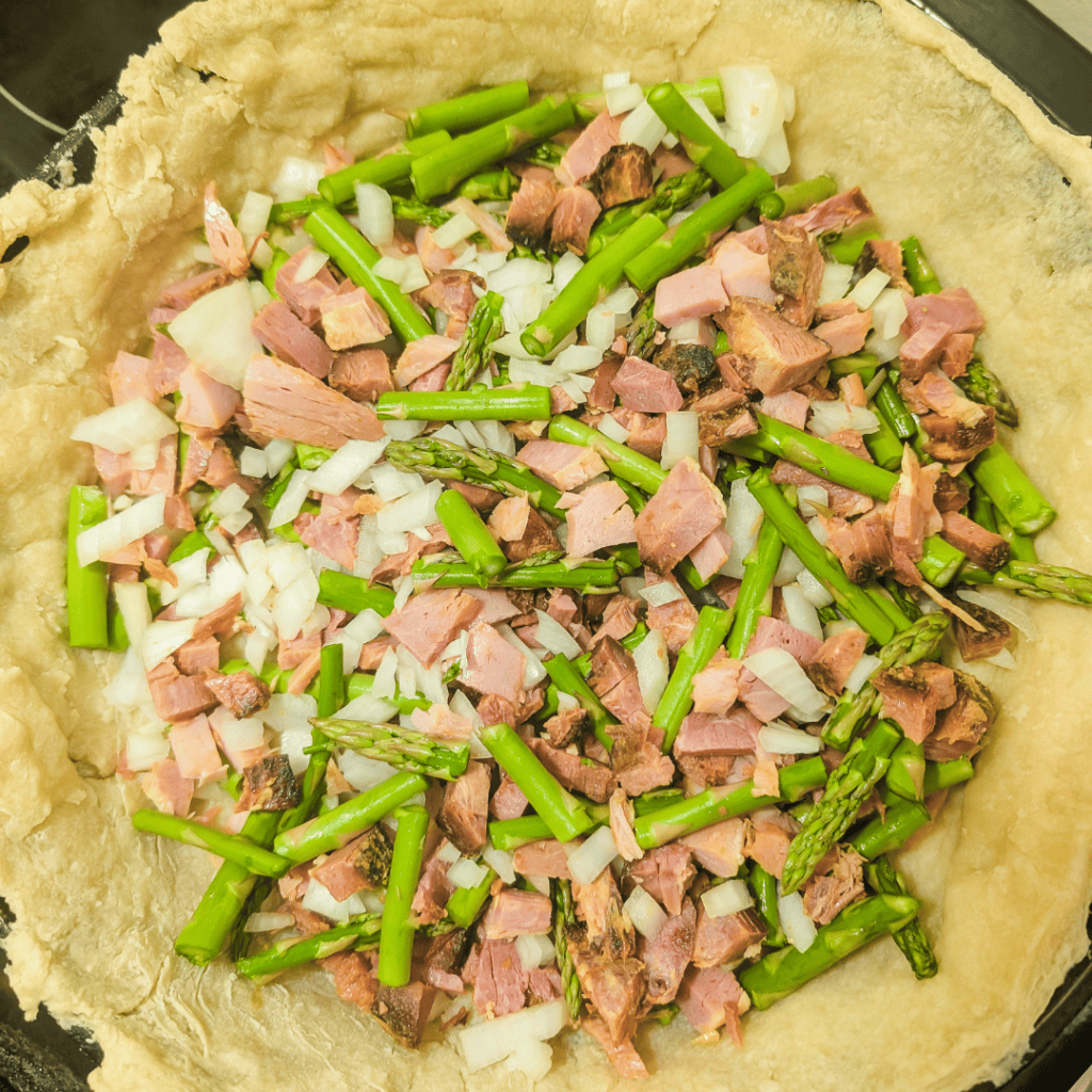 Ham and asparagus filling for family-sized quiche, ready to bake.
