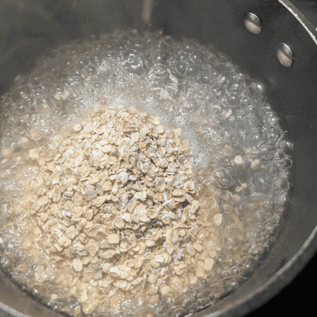 Cooking oatmeal with bananas and walnuts in a pot for a creamy breakfast.