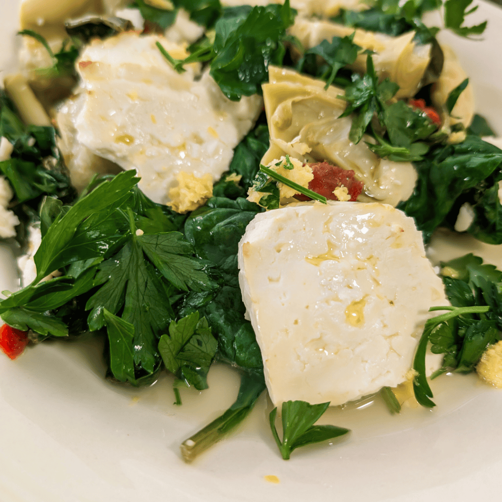 Delicious spinach artichoke bake featuring feta cheese and sun-dried tomatoes, perfect for a flavorf.