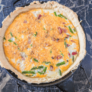 Delicious ham and asparagus quiche in a flaky crust, perfect for family meals.