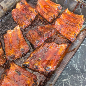 Delicious oven-cooked ribs coated with sticky maple glaze, perfect for a savory and sweet meal.
