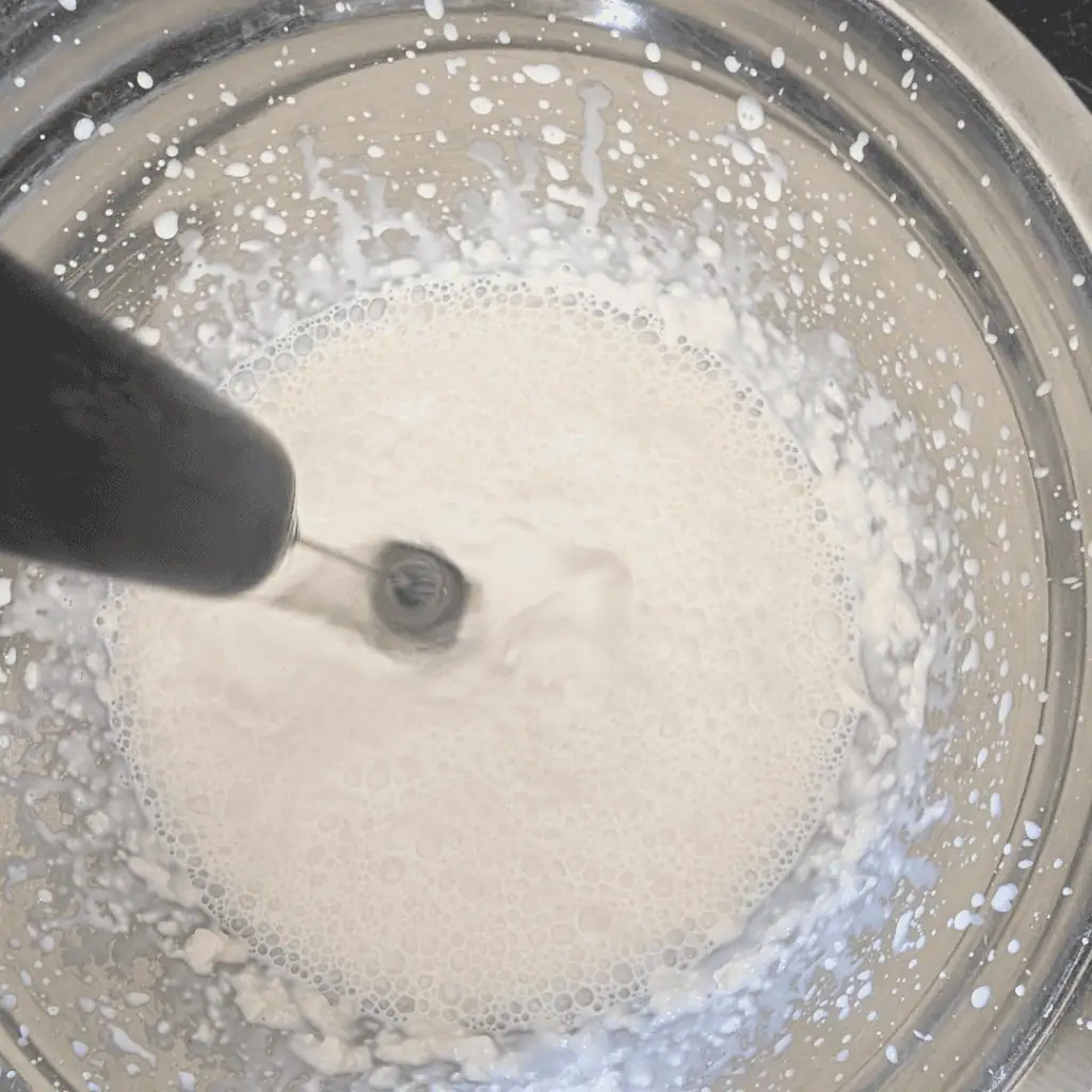 Blueberry ice cream base with blueberry reduction in a mixing bowl.