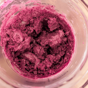 Close-up of vibrant blueberry ice cream with blueberry reduction topping.