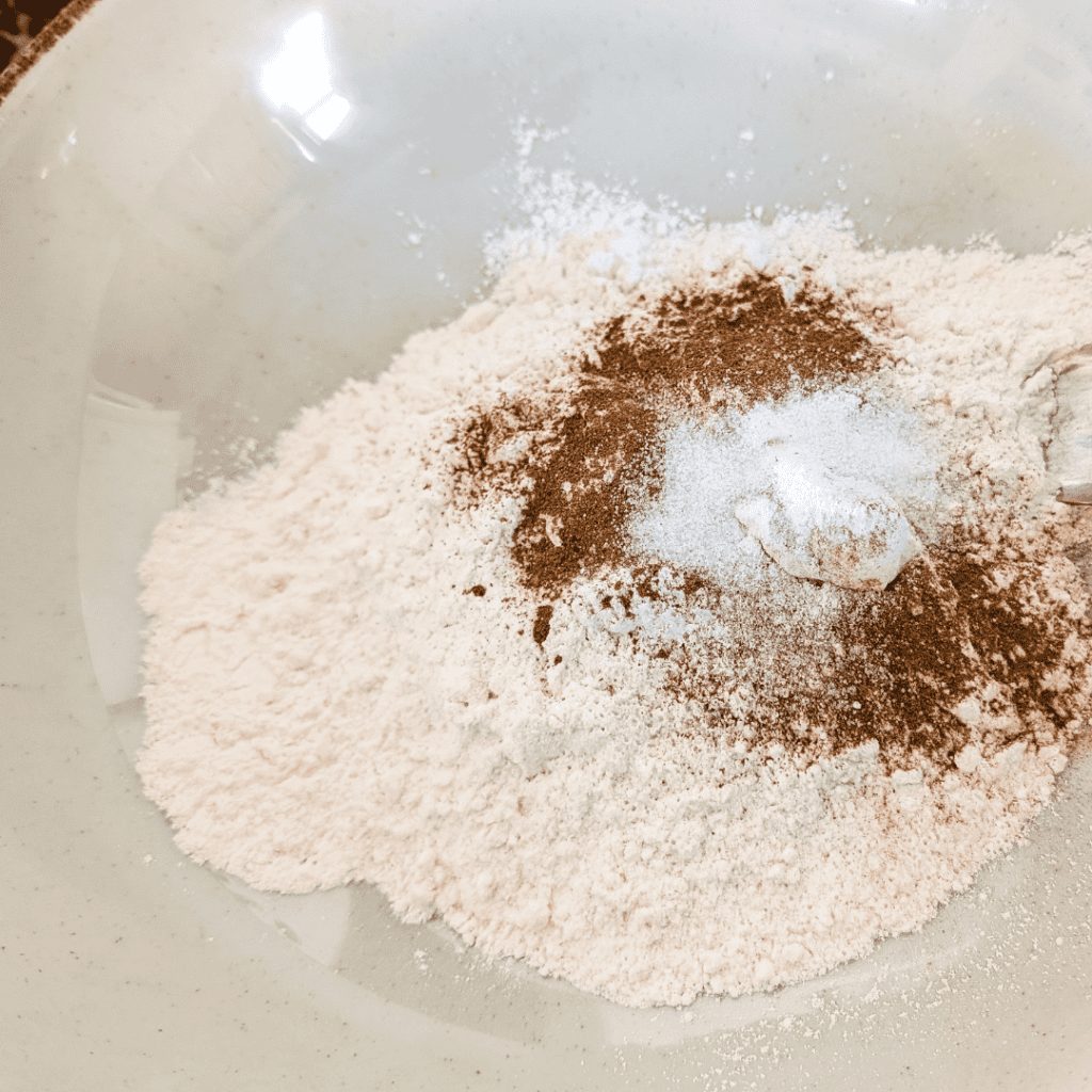 Flour and cinnamon powder mixture in a bowl for baking recipes.