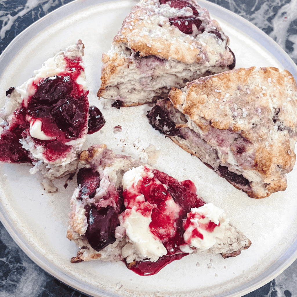 Delicious cherry pie slices with flaky crust and cherry filling on a white plate.