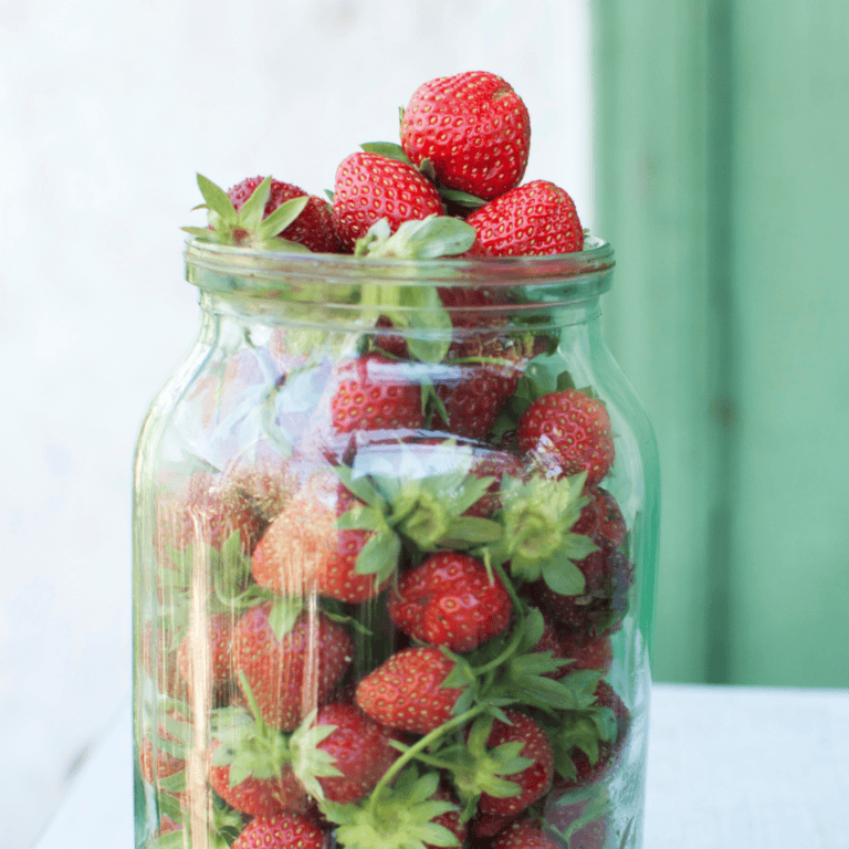 Fresh strawberries in a glass jar, perfect for healthy snacks and desserts.