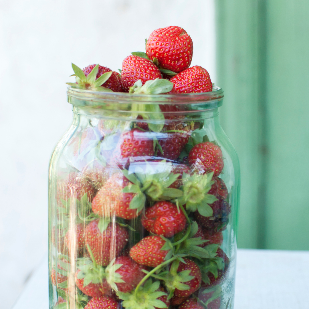 Fresh strawberries in a glass jar, perfect for healthy snacks and desserts.