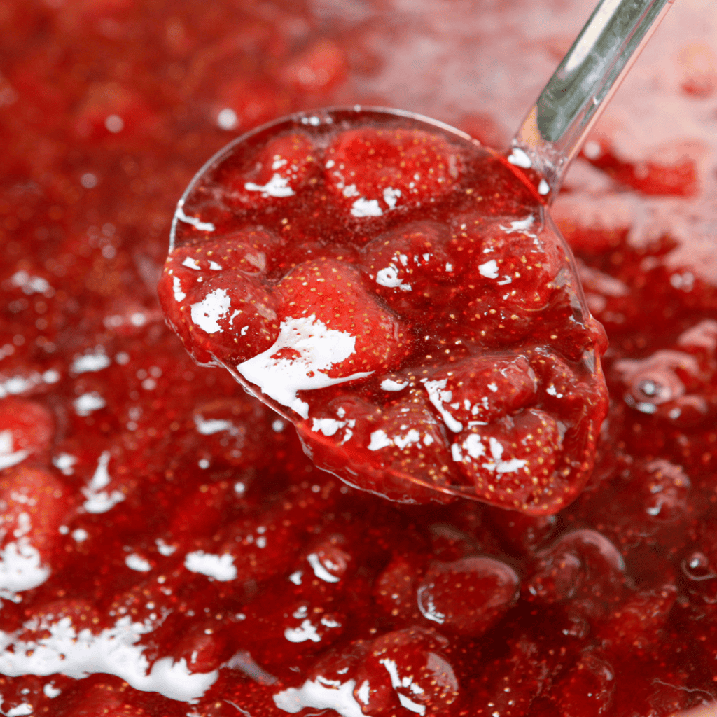 Fresh homemade strawberry jam in a spoon, close-up view.