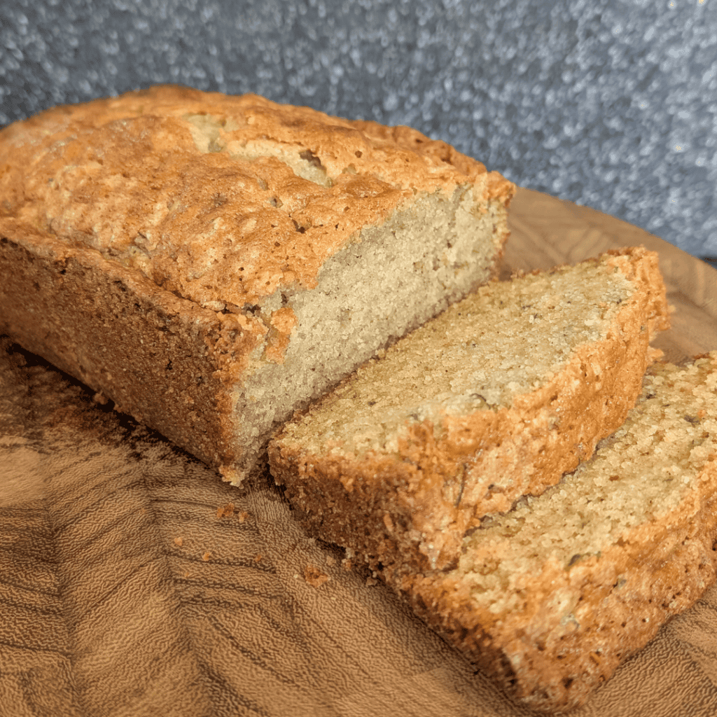 Freshly baked banana bread slices on a wooden cutting board.