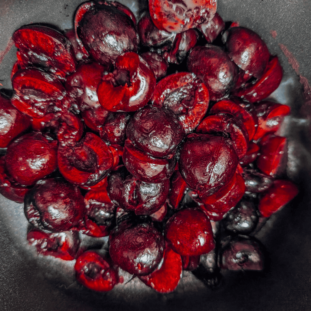 Fresh pitted cherries ready for cooking or baking, vibrant red color.