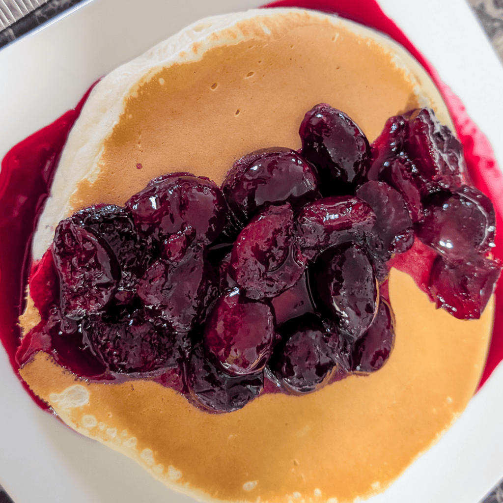 Pancake topped with fresh blueberries and syrup, perfect for breakfast or brunch.