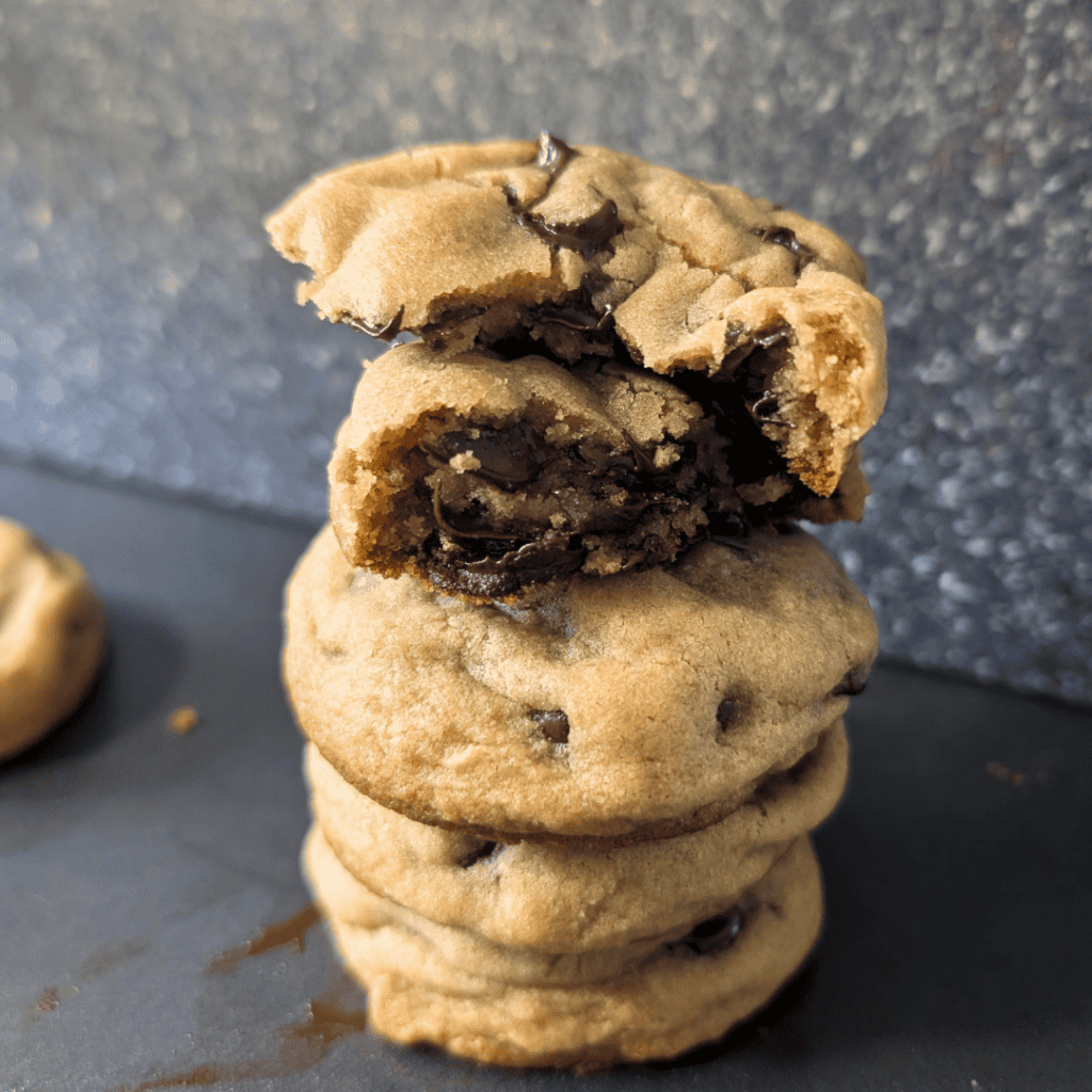 Stack of thick and soft chocolate chip cookies with melted chocolate.