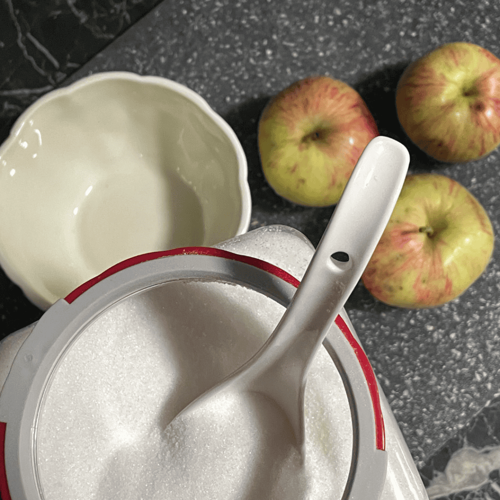 scooping white sugar for the apple pieces