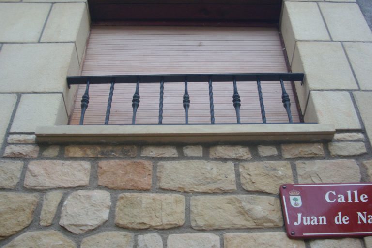 Reja de hierro para ventanas, protección segura y decorativa en fachadas de piedra.