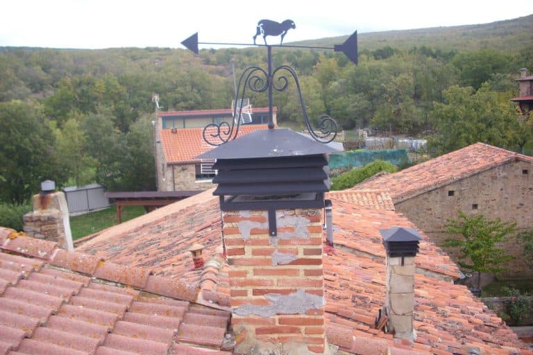 Ventilación en chimenea de estufa en tejado de ladrillo antiguo.