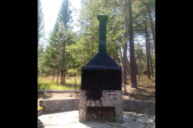 Barbacoa de exterior para carnes y asados en entorno natural, ideal para camping, picnic y reuniones familiares.