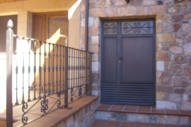 Puerta de cierre de seguridad de cerrajería Osfran en fachada de piedra.