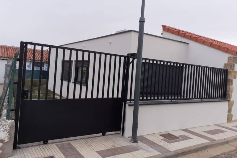 Puerta de hierro galvanizado con barandilla para protección y seguridad en viviendas.