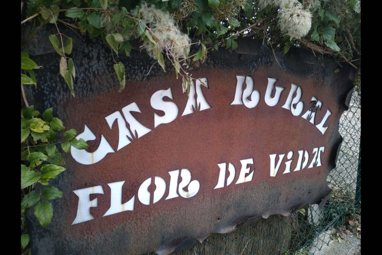 Señal de cerrajería oxidada con letras blancas destacadas, ubicada en exterior de negocio.