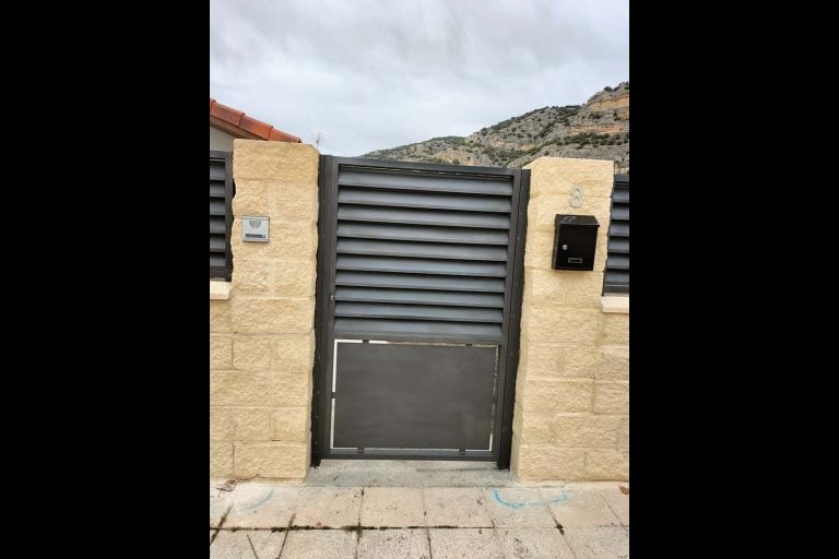 Puerta de metal negra con diseño de lamas horizontales, ideal para viviendas.