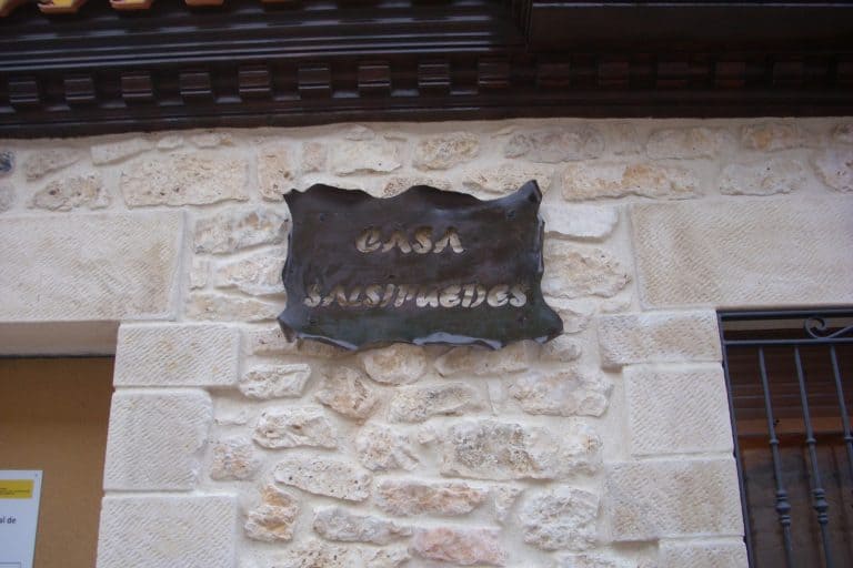 Puerta de casa con placa de hierro forjado y ladrillos de piedra, servicio de cerrajería OSFRAN.