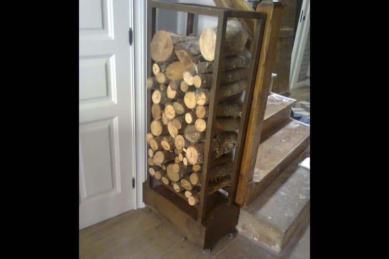 Estantería de madera para almacenamiento de troncos de leña en interiores.