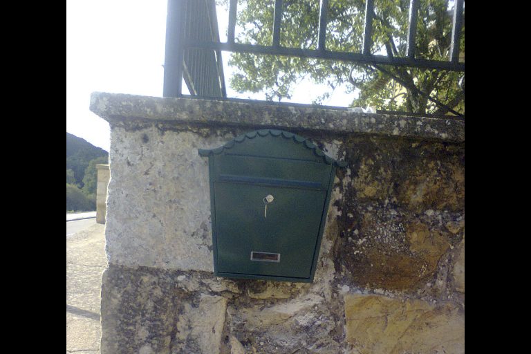 Buzón de correo en pared de piedra para envío y recibo de cartas y paquetes.