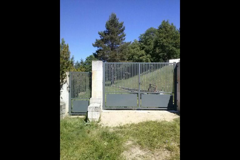 Puerta de cancela de hierro gris en entrada principal de propiedad privada.