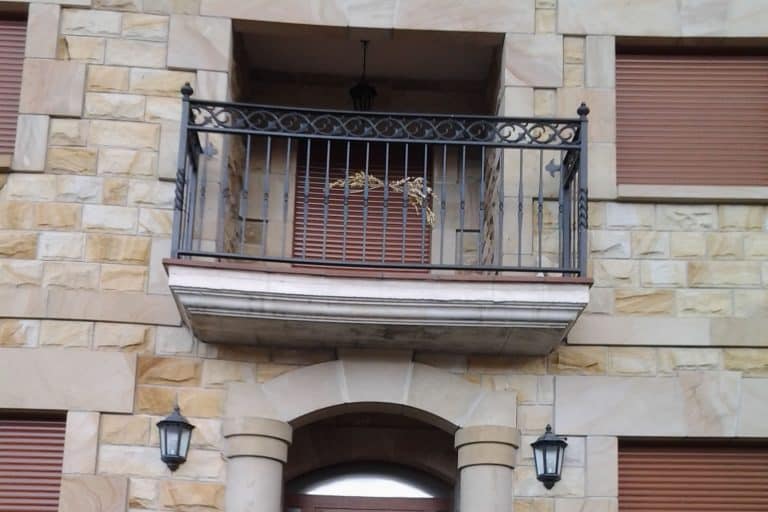 Balcony railing repair on building facade. Locksmith services by Osfran, specialists in locks, doors, and ironworks.