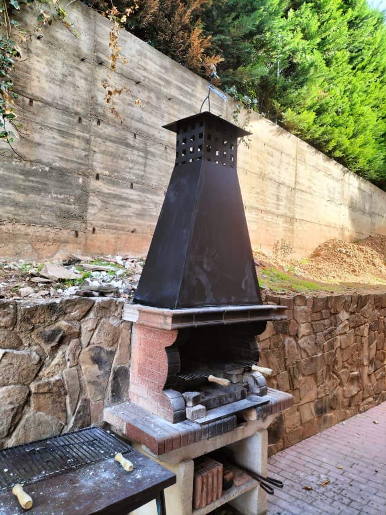 Puerta de chimenea de ladrillo y metal, perfecta para exteriores.