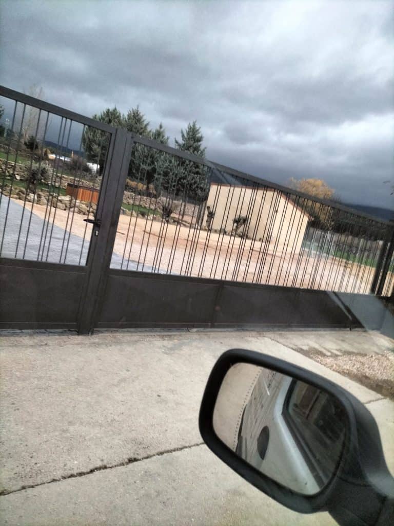 Puerta de hierro para jardín con acabado negro y diseño robusto, ideal para seguridad y estética.