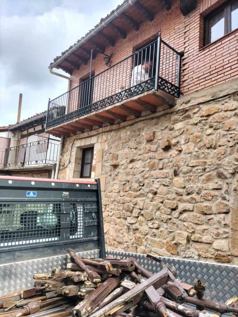 Puerta de balcón de hierro con acabado elegante en una vivienda de estilo rústico.