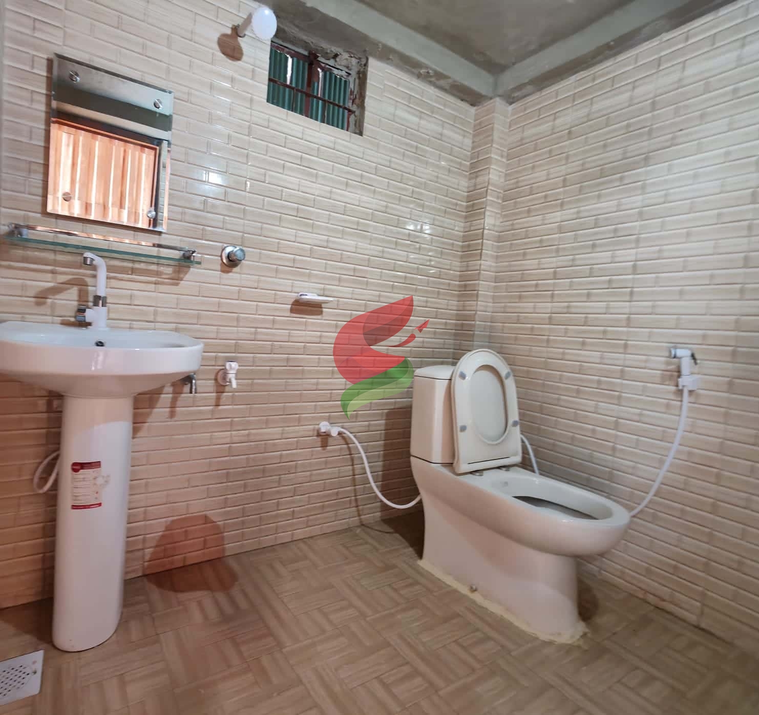 Spacious bathroom in Room B1 featuring a toilet, sink, and tiled walls for comfort and functionality.