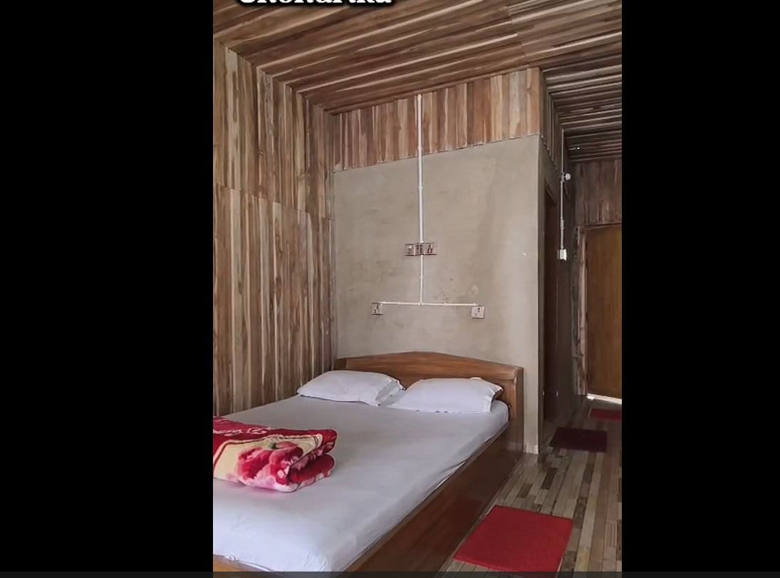 Cozy wooden interior bedroom at Check In Cherish hotel with comfortable bed and minimalist decor.