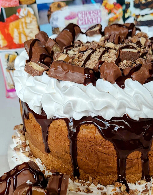Delicious cheesecake topped with chocolate, cookies, and whipped cream.