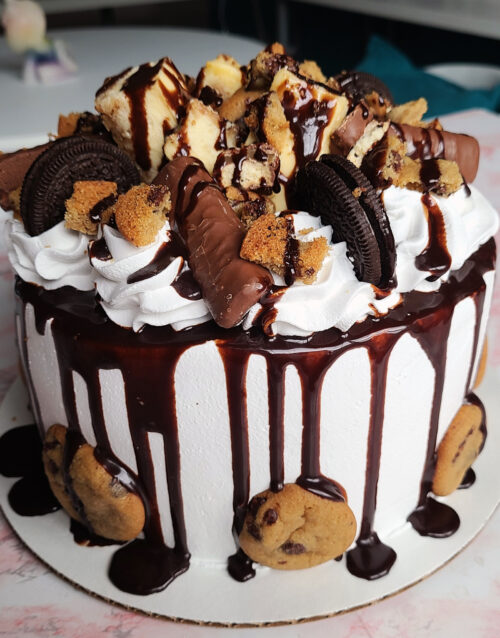 Delicious 8-inch cheesecake topped with cookies, Oreos, and chocolate drizzle.