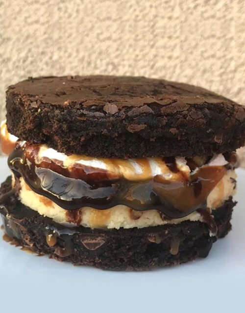 Delicious brownie cheesecake sandwich with rich chocolate, creamy filling, and caramel drizzle. Perf.