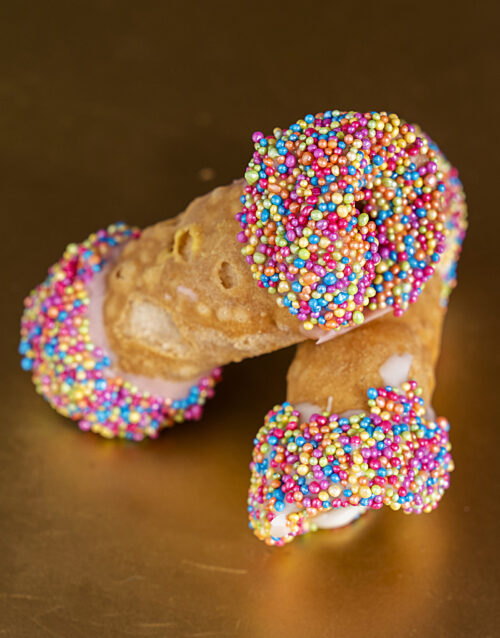 Delicious cannolis with colorful sprinkles, perfect for dessert or celebration treats.