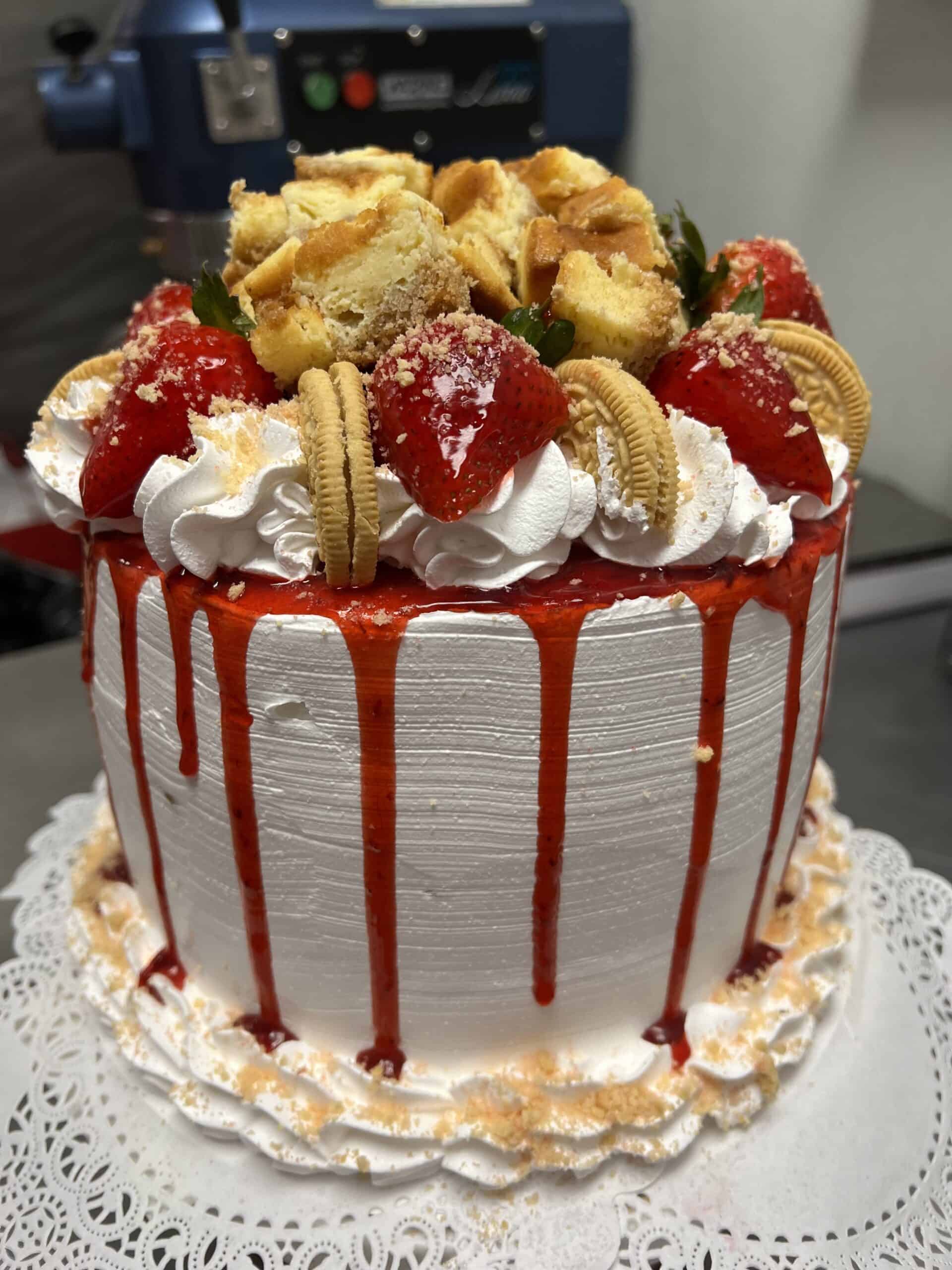Delicious strawberry shortcake cheesecake with whipped cream, cookies, and strawberry toppings.