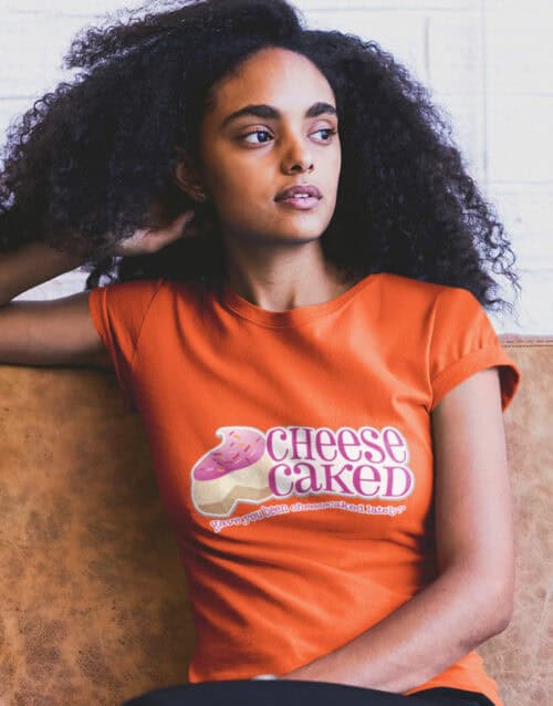 Woman wearing CheeseCaked branded T-shirt with cheese logo, casual style.