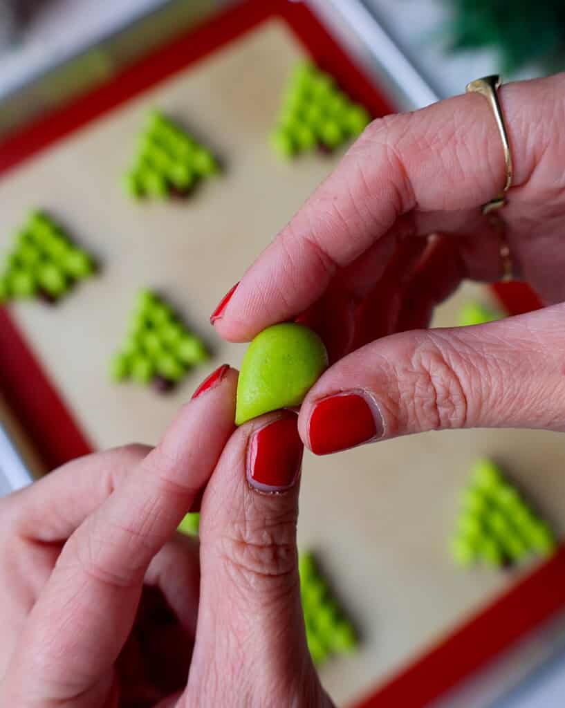 image of cookie dough being shaped to make christmas tree cookies